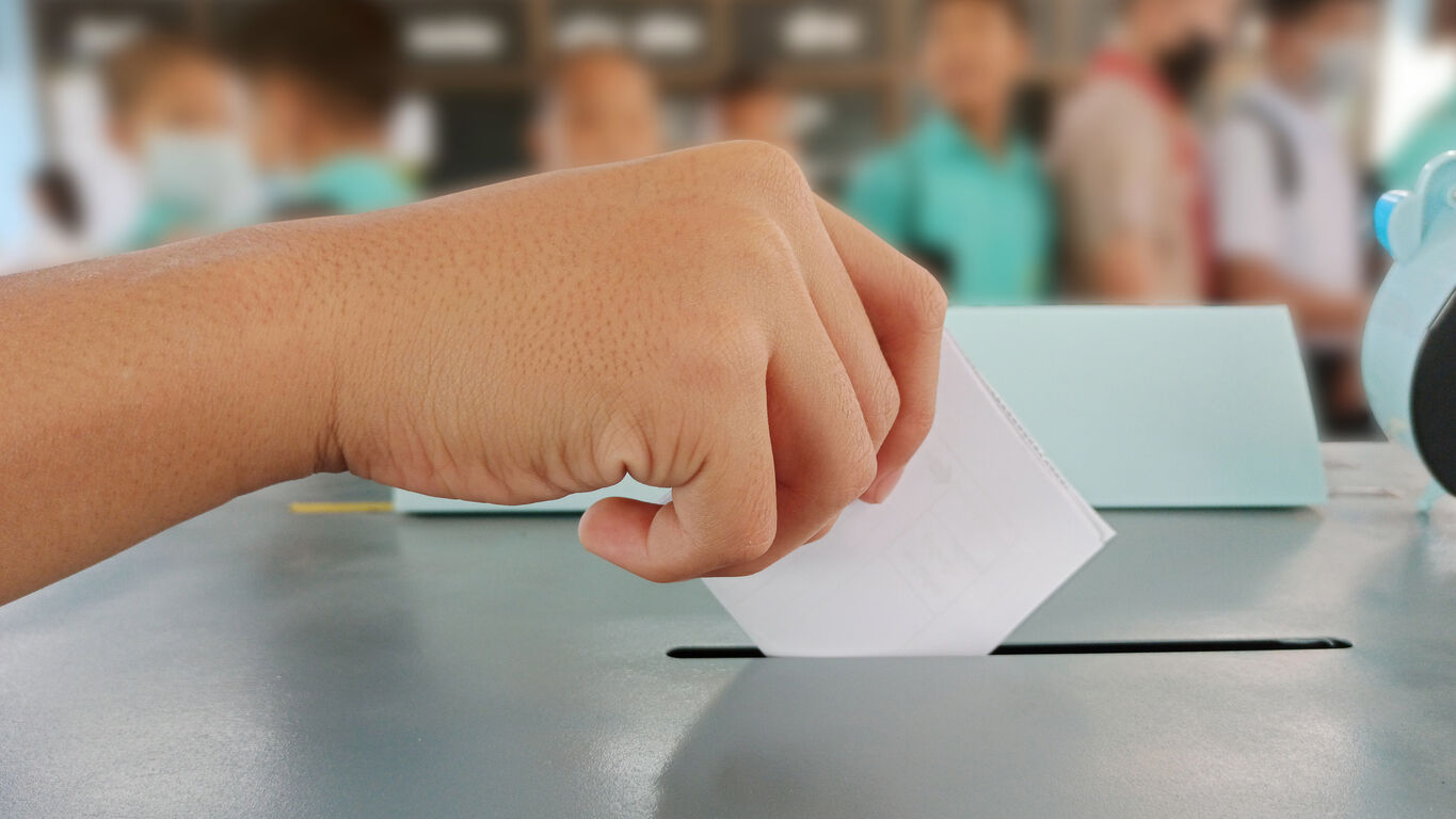 Students hands voting in the ballot box